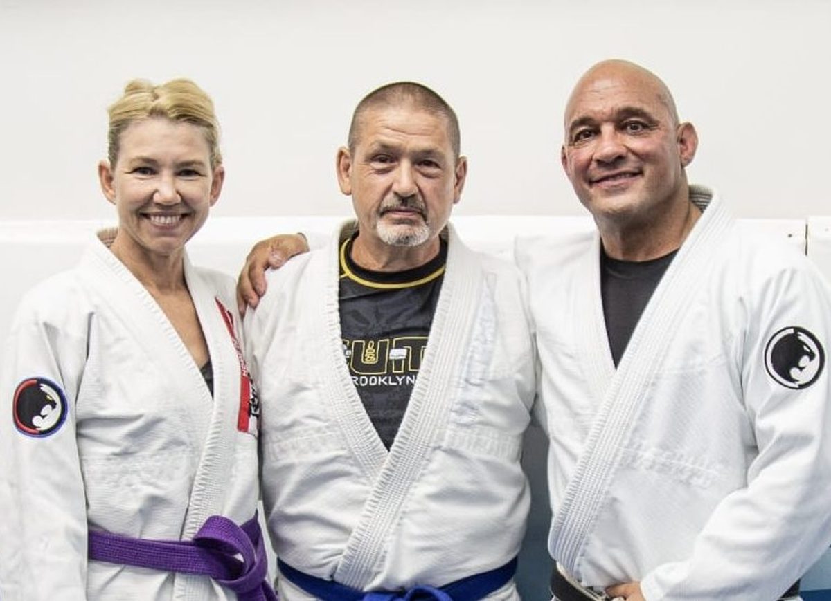 Professor Mark Cerrone with two adult members in gis after a belt promotion